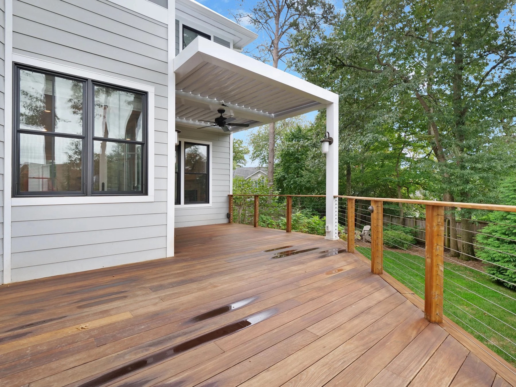 Covered rear deck with a mechanical louvered roof